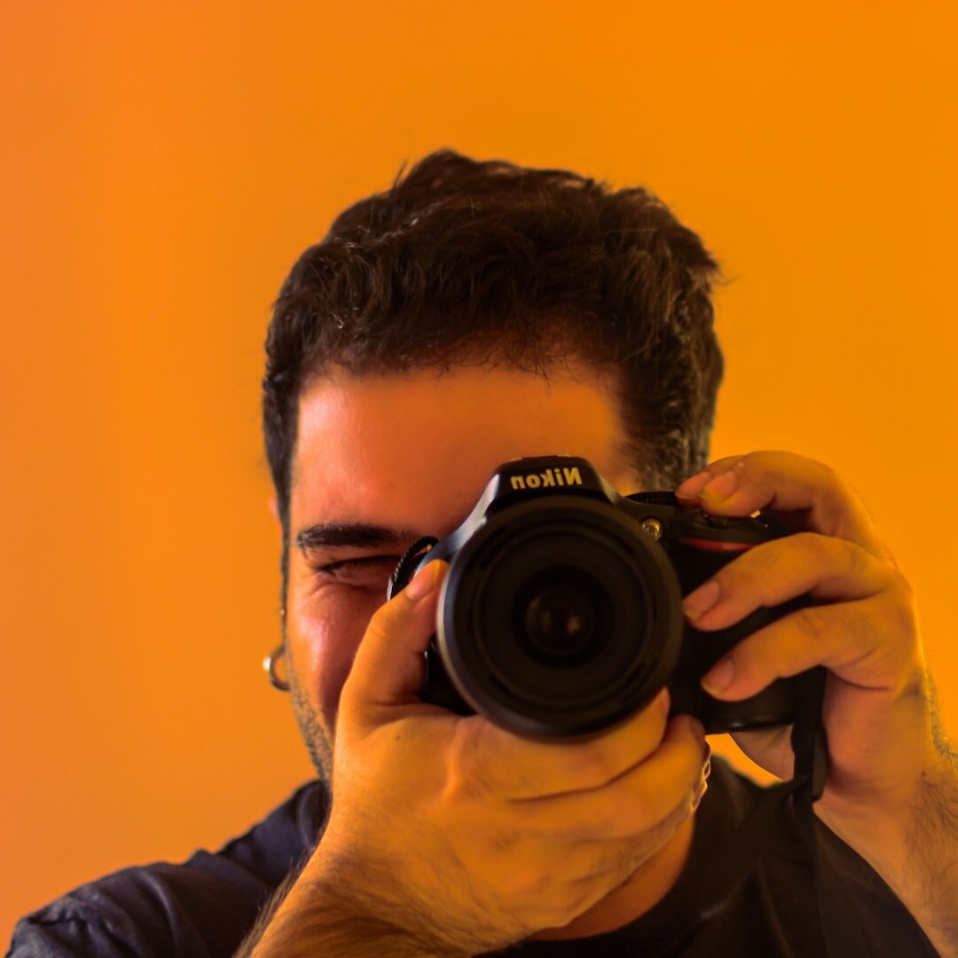 Studio portrait of a man holding a video camera